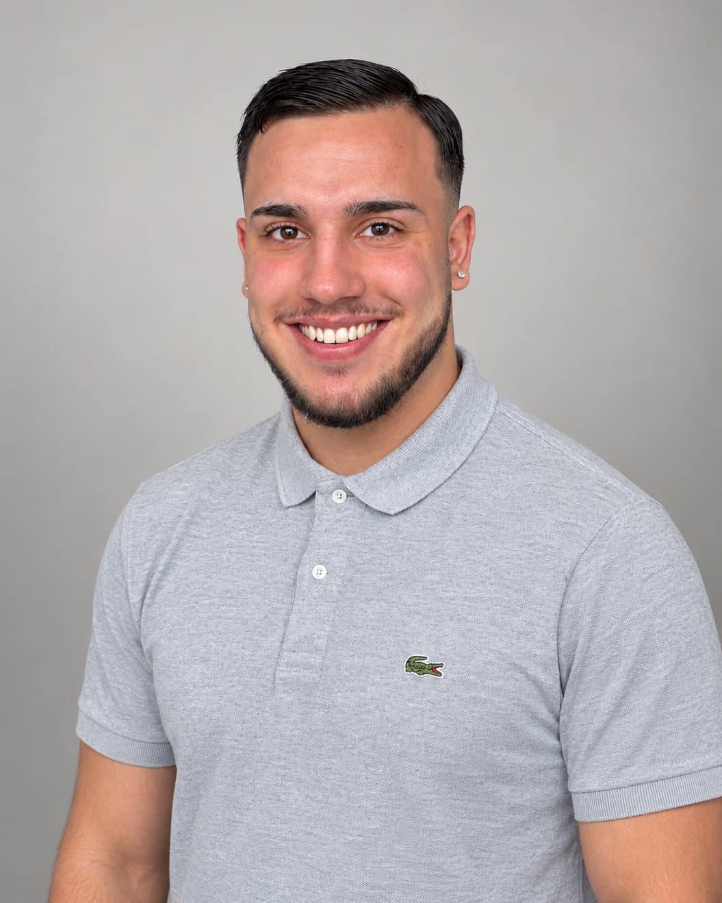 Marlon Minio, Inhaber von Minio Grabpflege, lächelnd im grauen Poloshirt